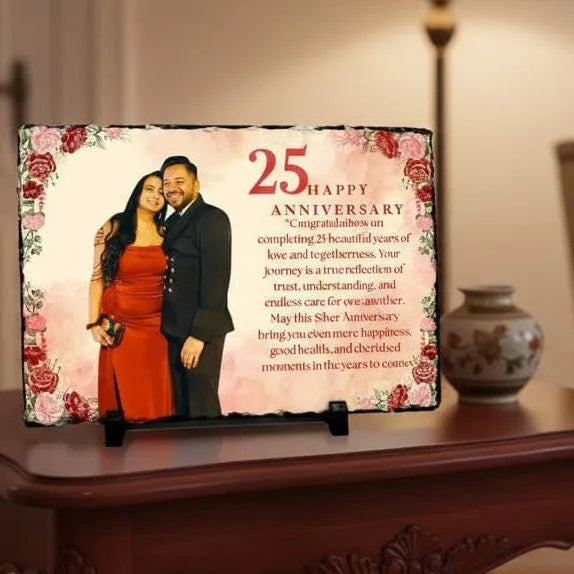 Decorative plaque for a 25th anniversary on a wooden table with a vase in the background.