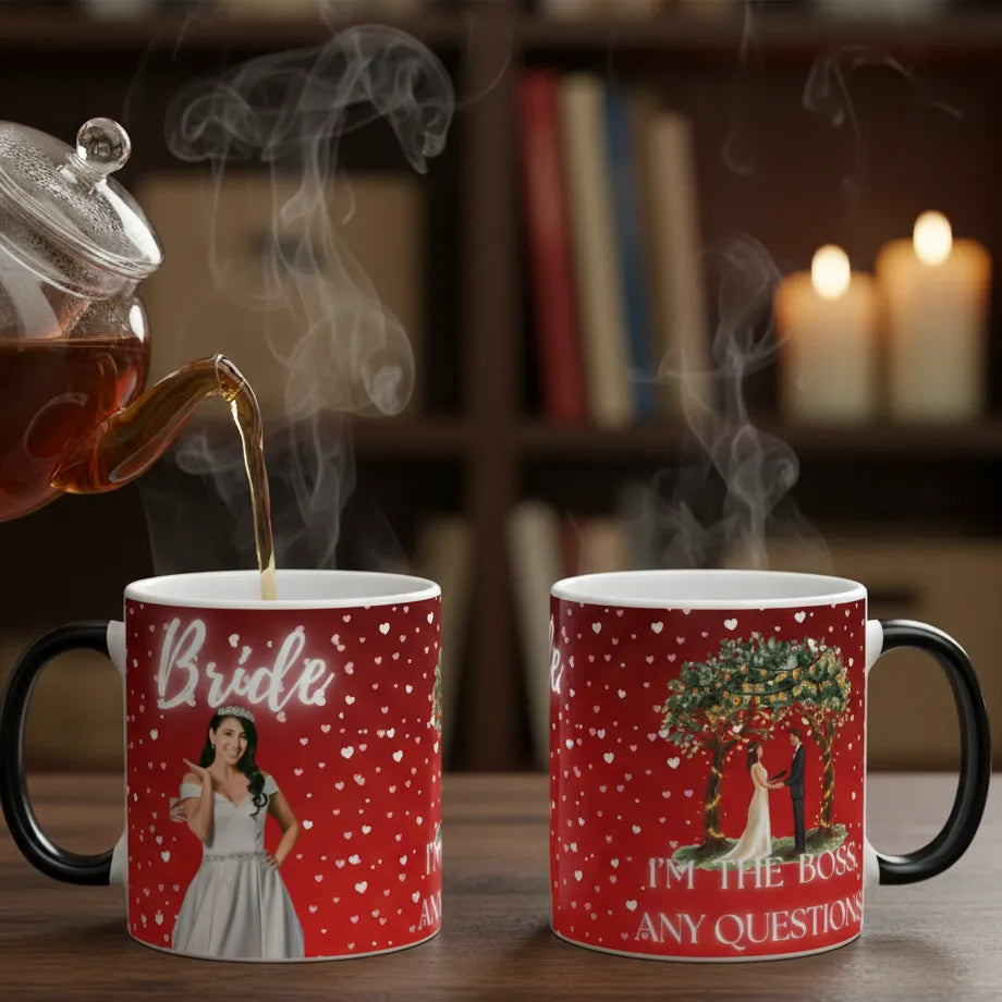 Two red mugs with printed designs being filled with steaming hot liquid, set against a cozy background with candles and books.