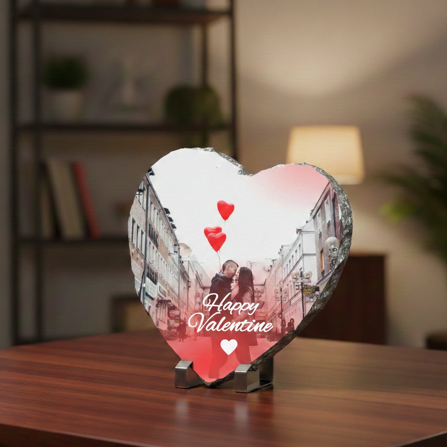 Heart-shaped photo display with a romantic scene and 'Happy Valentine' text on a wooden surface.