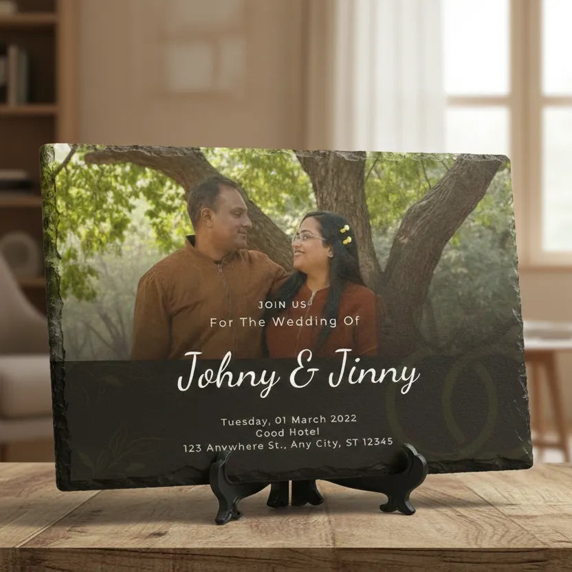Wedding invitation card with a couple under a tree on a wooden stand.