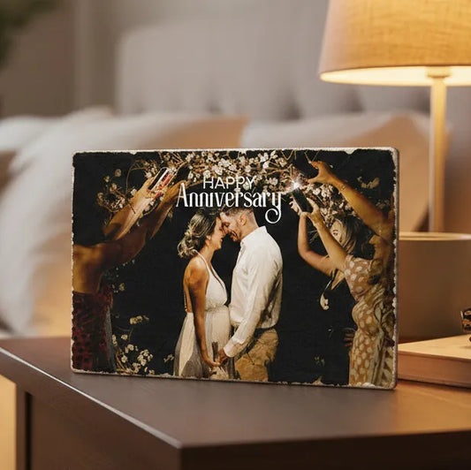 Personalized 'Happy Anniversary' photo album on a table with a cozy background