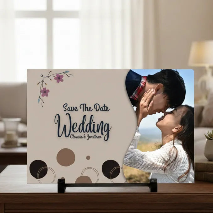 Save the Date wedding card with a couple kissing on a stand in a living room.