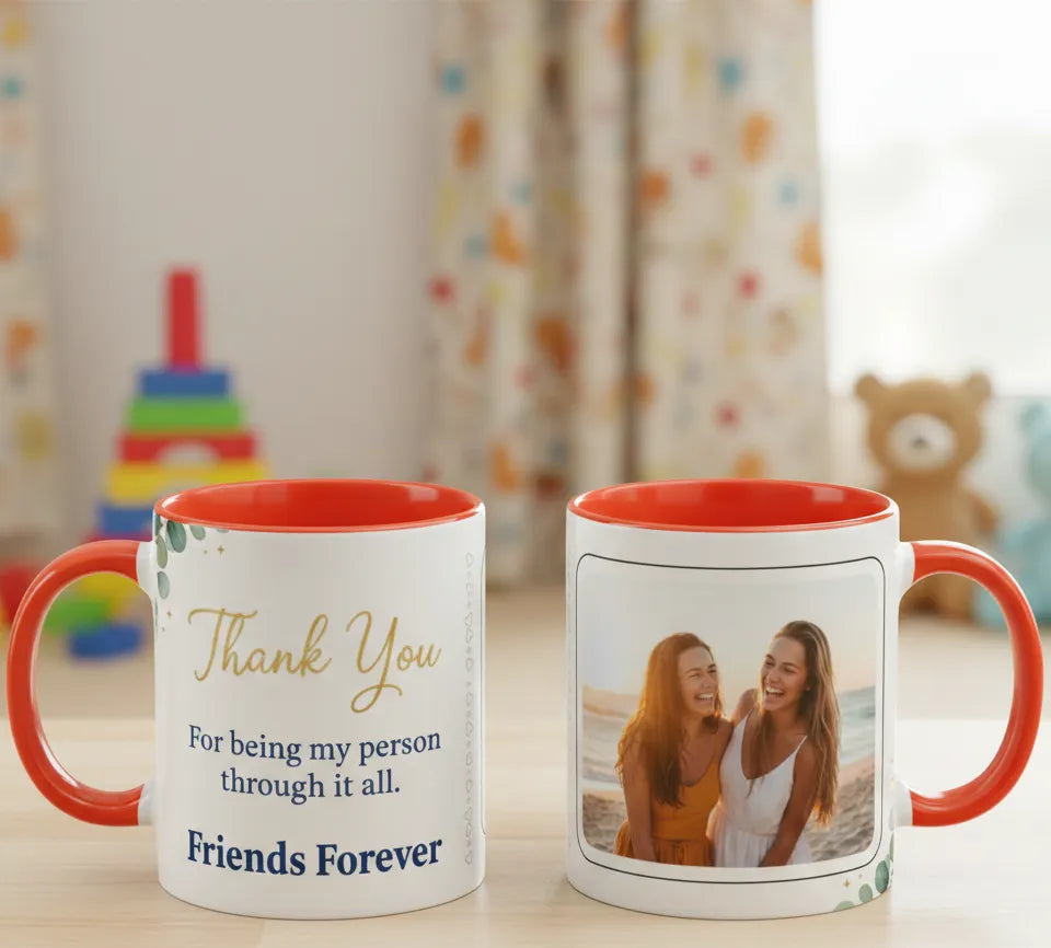Two mugs with red interior and handles on a table, one with text and the other with a photo of two people.